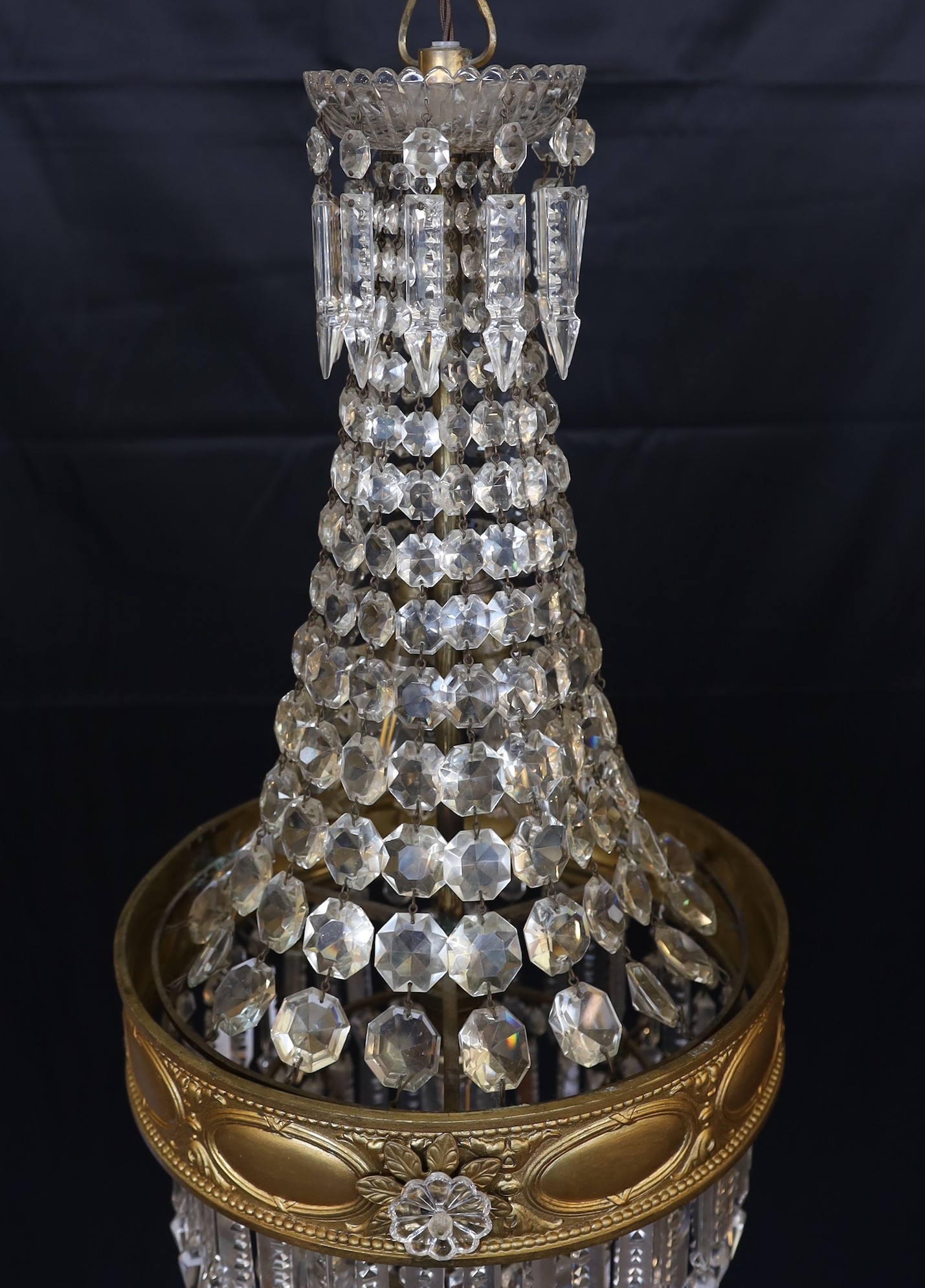 An early 20th century English ormolu and cut glass bag chandelier, hung with octagonal cut drops and spear shaped lustres with four tiers to the base, height 75cm. diameter 35cm